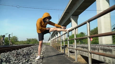 Asian young runner man wearing  surgical face mask stretching leg warm up bef Stock Footage 146654358