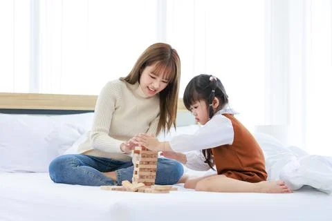 Asian young teenage female mother nanny babysitter in casual sweater and jean Stock Photos