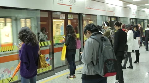 Asians are on the subway platform and look in Gadgets Stock Footage 45162403
