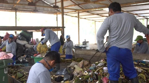 Asiatic men in respirators sort garbage. shovels scoop up waste.plastic products Stock Footage 127046864