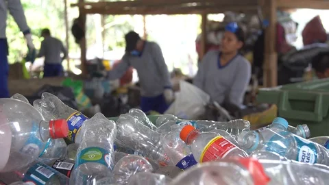 Asiatic men in respirators sort garbage. empty plastic bottles in the foreground Stock-Footage 127369873