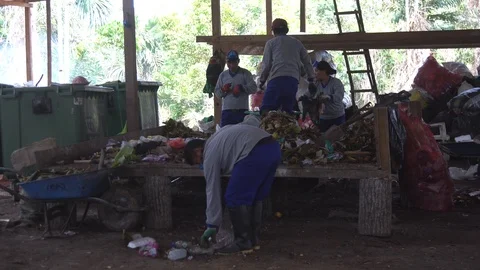 Asiatic men in respirators sort garbage. shovels scoop up waste. Video stock 127369905