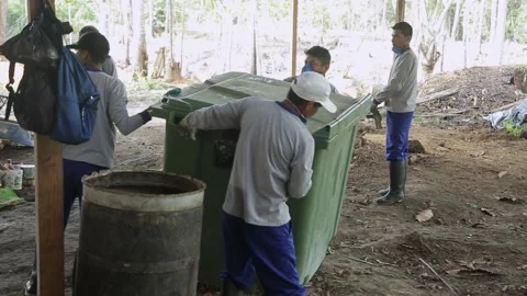 Asiatic men in respirators sort garbage. shovels scoop up waste. Stock Footage 230700961