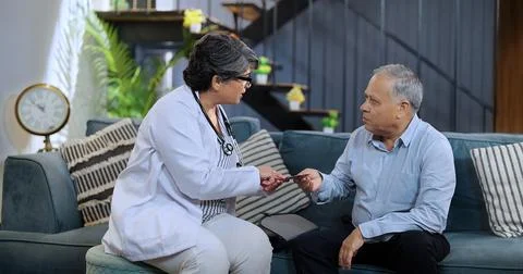 Asinan general practitioner talking with serious middle aged man Stock Photos