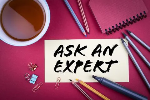 ASK AN EXPERT. Tea cup and office supplies on a red table Stock Photos
