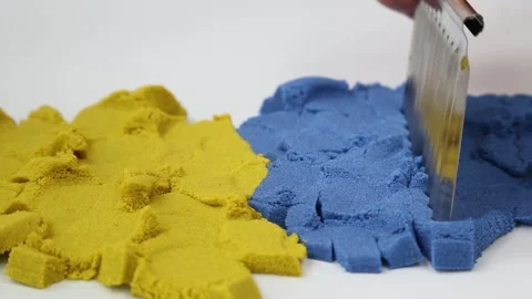 ASMR. Soft, textured, colored, kinetic sand knife slowly cuts into many pieces. Stockbeeldmateriaal 256186754