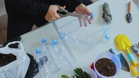 ASMR video showing someone cutting plastic bottles with scissors for DIY Video stock 343728849