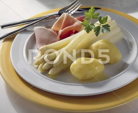 Asparagus with boiled ham, butter and potatoes Stock Photos