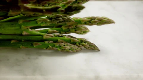 Asparagus fall on marble cutting board in slow motion Stock Footage 156872337