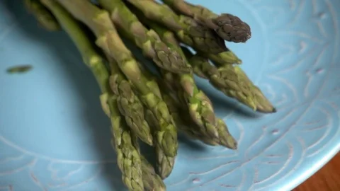 Asparagus falling onto plate, slow motion Video stock 77336885