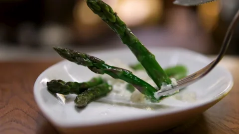 Asparagus plate fork Grilled asparagus served in restaurant on a plate with Stock Footage 302278490