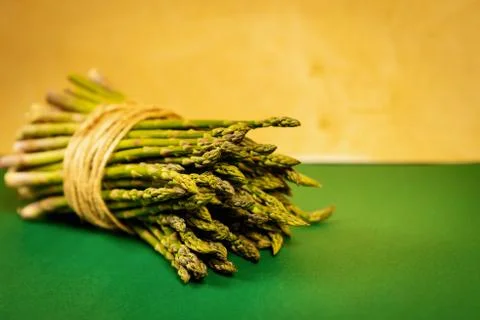 Asparagus tied with a thin string on a yellow summer background Stock Photos