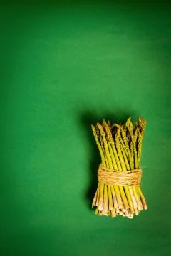 Asparagus tied with a thin string on a yellow summer background Foto stock