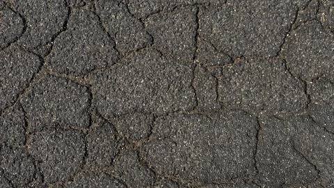 Asphalt background texture with cracks. Cracked asphalt road texture. Stock Photos
