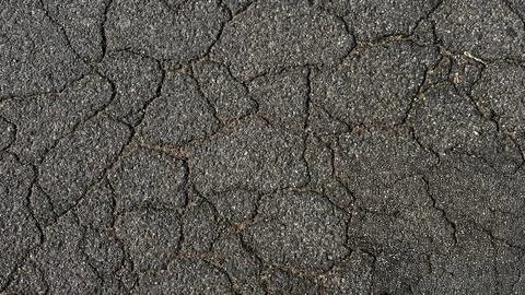 Asphalt background texture with cracks. Cracked asphalt road texture. Stock Photos