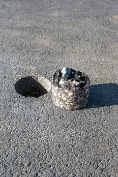 Asphalt core sample on pavement near drilled hole used for laboratory testing 写真素材