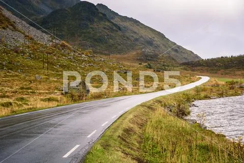 Asphalt curved road along mountain, Lofoten, Norway Stock Photos