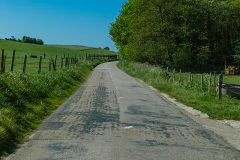 Asphalt empty road passing through the fields in the region of Normandy, France Stock Photos
