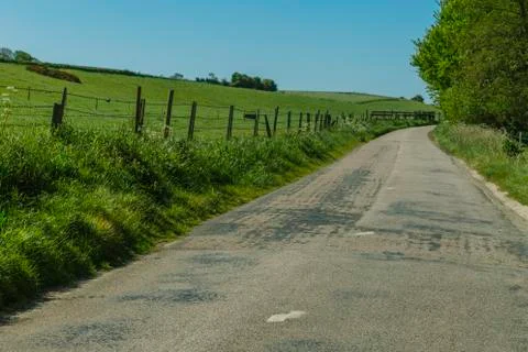 Asphalt empty road passing through the fields in the region of Normandy, France Stock Photos