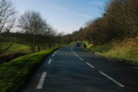 Asphalt empty road passing through the forest in the region of Normandy, France 스톡 사진