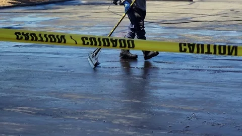 Asphalt maintenance technicians  working on new pavement Stock Footage 342479078