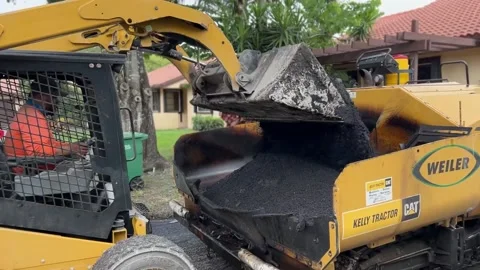 Asphalt Paving Skid Steer with load of hot asphalt dumps bucket into asphalt  Stock Footage 217402668