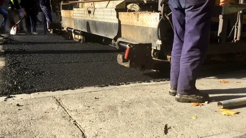 Asphalt paving track machine, pouring asphalt on rough road pavement Stock Footage 82408980