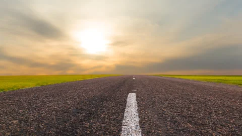 Asphalt road among green fields at the sunset time lapse scene Stock Footage 155108109