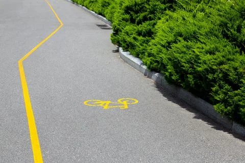 An asphalt road with a bicycle path marking along the curb. Stock Photos