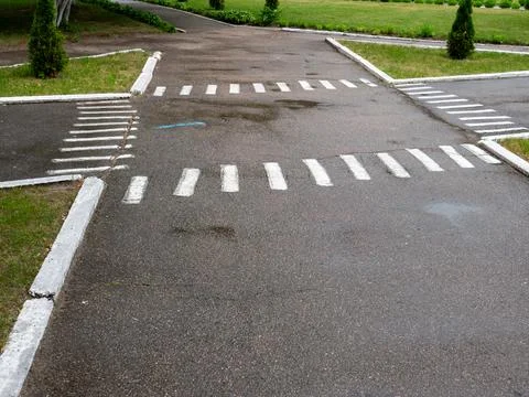 Asphalt road intersection with white zebra pedestrian crossings Stock Photos