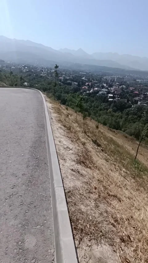 An asphalt road leading down a hill. 库存影片 345946943