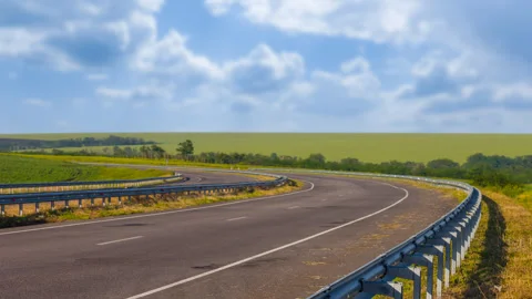 Asphalt road leaving far under cloudy sky time lapse scene Stock Footage 246362006