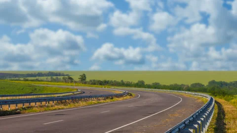 Asphalt road leaving far under cloudy sky time lapse scene Stock Footage 249651247