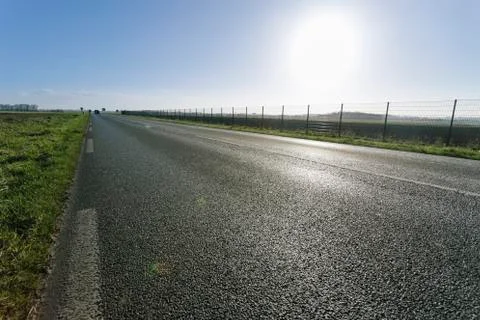 Asphalt road passing through the fields in the region of Normandy, France Stock Photos