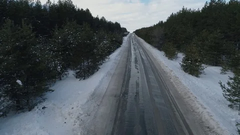 Asphalt road passing through the pine forest. On the winter, forest road traffic Video stock 108525574