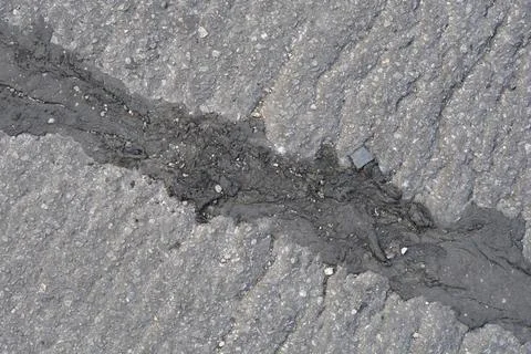 Asphalt road texture with rough tar repair sealant filling Stock Photos