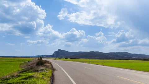 Asphalt road through a green fields time lapse scene Stock Footage 297759368