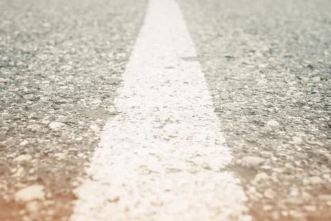 Asphalt road with white solid line, closeup. Stock Photos