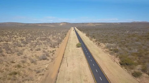 Asphalt road with wide fire break in arid bush veld aerial shot Stock Footage 80597039