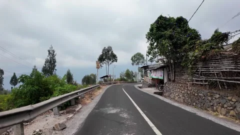 Asphalt road winds through green hills with trees Stock Footage 345152564