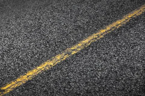 Asphalt road with yellow solid line. Transportation background texture Stock Photos