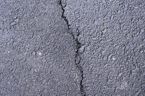 Asphalt texture with a deep crack, close-up top view, industrial background Stock Photos