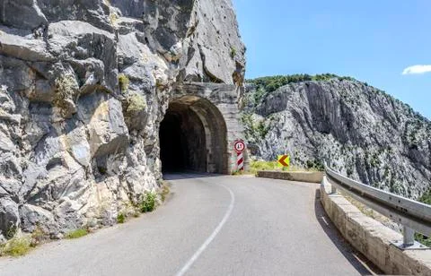 Asphalted mountain road with sharp turn near the cliff. Stock Photos
