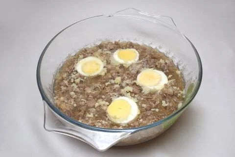 Aspic jelly with boiled meat pieces and halved eggs. frozen bone broth in g.. Stock Photos