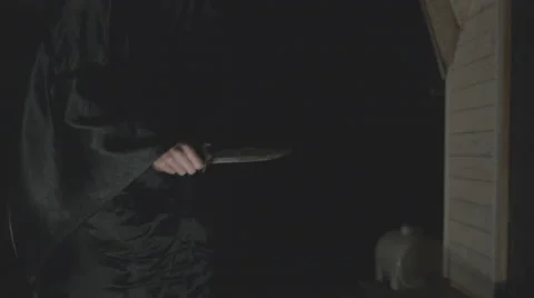 Assasin in a cape with a knife in his hand enters a house Stock Footage 59377440