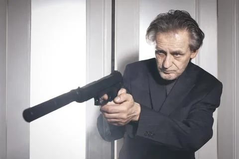 Assassin armed with semi automatic pistol with silencer be aware Stock Photos