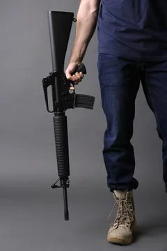 Assault gun. Man holding rifle on dark background, closeup Stock Photos