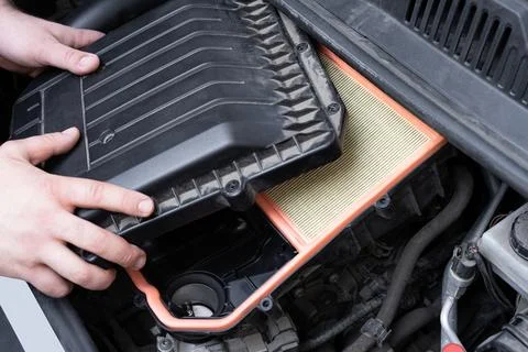 Assembilng air box with new filter in car engine bay. Stock Photos