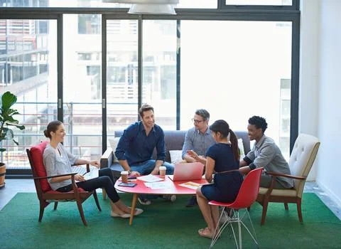 An assemblage of sharp minds. a group of office workers talking together in a Stock Photos