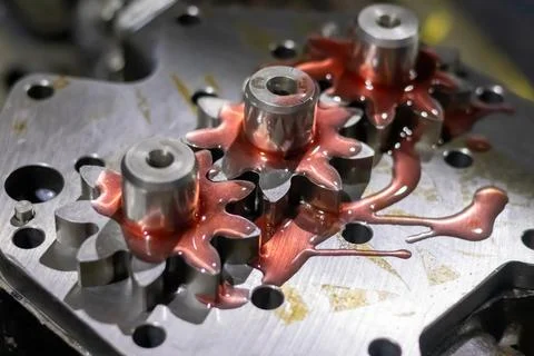 Assembled pump spur gears covered in red transmission fluid inside mechanic.. Stock Photos